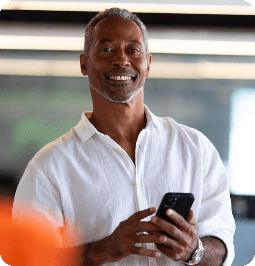 Imagem de uma pessoa feliz com o celular na mão.